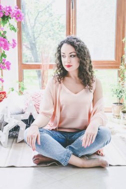 Pencerenin yanında kupası olan güzel bir kız.