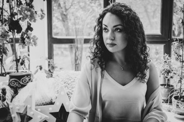 Pencerenin yanında kupası olan güzel bir kız.