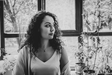 Pencerenin yanında kupası olan güzel bir kız.