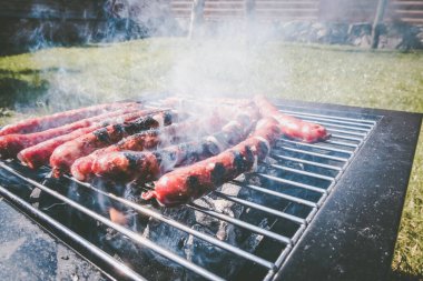Sosisler ızgara, açık hava eğlencesi. Taşınabilir barbekü