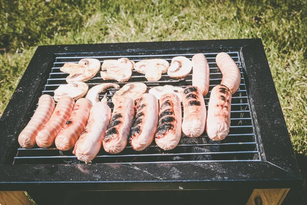 Sausages grilled, outdoor recreation. Portable barbecue