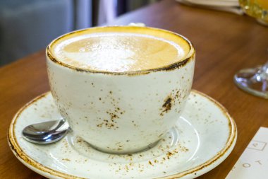 Masada bir bardak kapuçino.