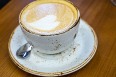 Masada bir bardak kapuçino.