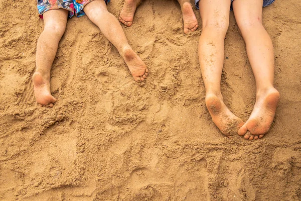 Children's feet on the sand on the sea beach