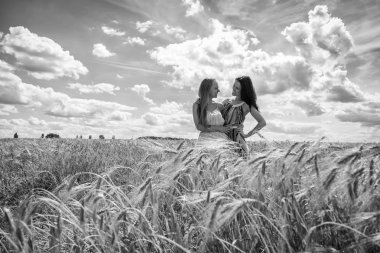 buğday alanında duran iki genç kız.
