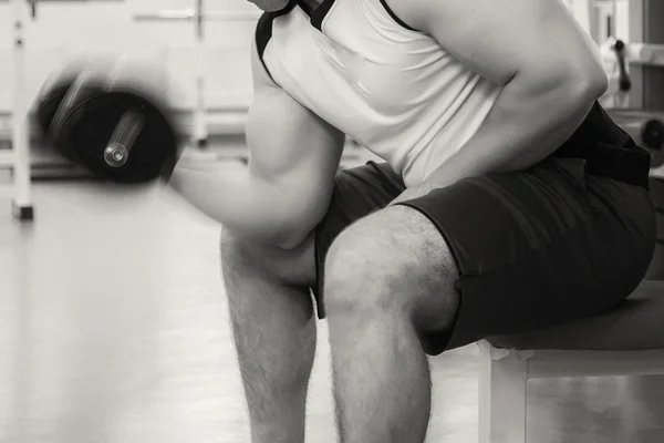 Homem faz exercícios com halteres . — Fotografia de Stock