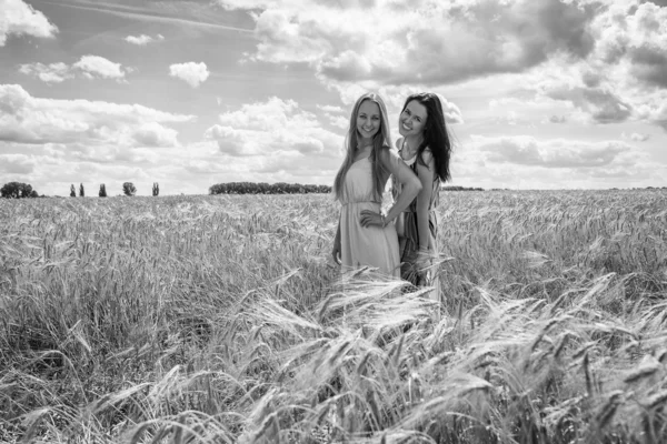 Due ragazze in piedi in un campo di grano . — Foto Stock