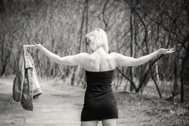 Genç bir kadın ormanda yürüyor.