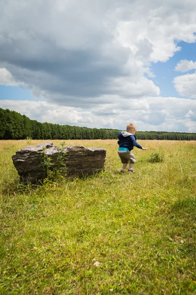 Kleine jongen in het midden van het veld — Stockfoto