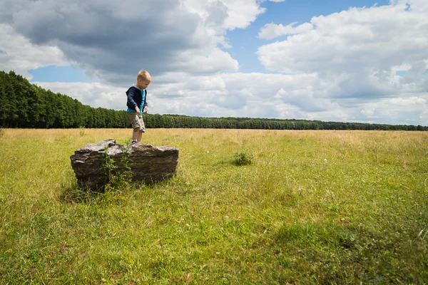 Kleine jongen in het midden van het veld — Stockfoto