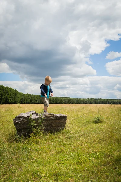 Kleine jongen in het midden van het veld — Stockfoto