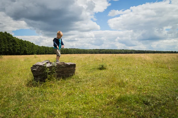 Kleine jongen in het midden van het veld — Stockfoto