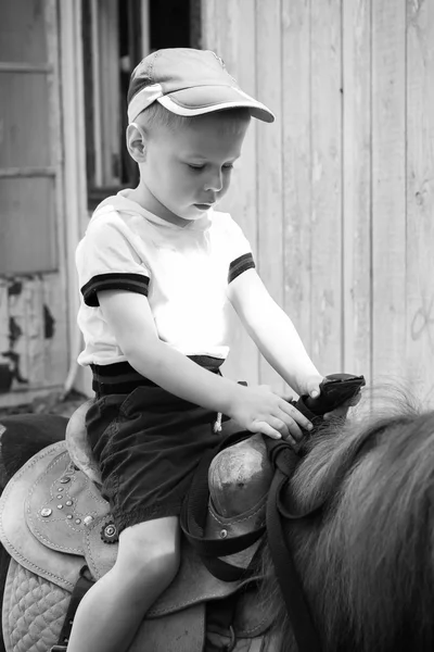 Kleiner Junge reitet Pony — Stockfoto
