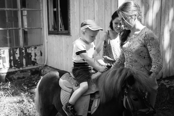 Petit garçon chevauchant poney — Photo