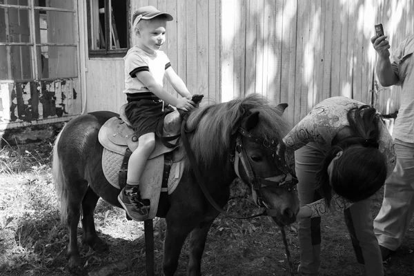 Little boy riding pony — Stock Photo, Image