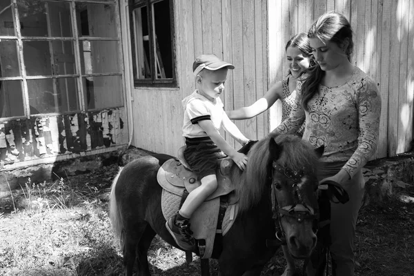 Pequeño niño montando pony — Foto de Stock