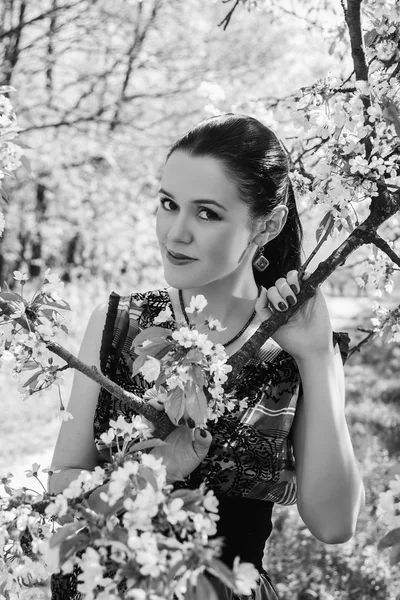 Chica cerca de un árbol floreciente — Foto de Stock