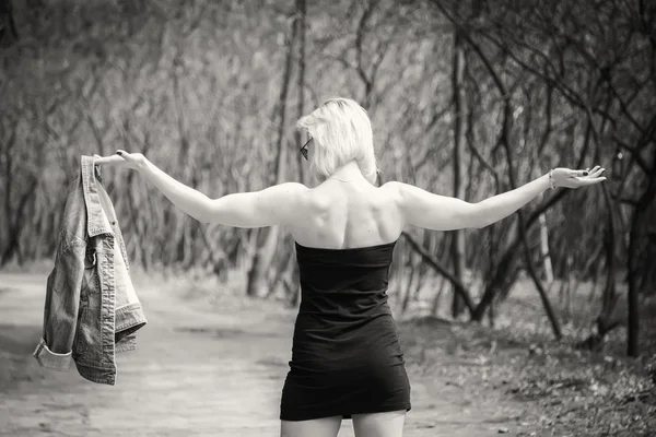 Genç bir kadın ormanda yürüyor.