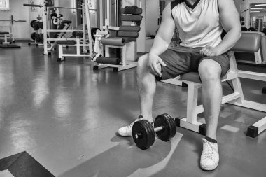 adam dumbbells ile çalışmaları yapan.