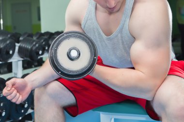 adam dumbbells ile çalışmaları yapan.