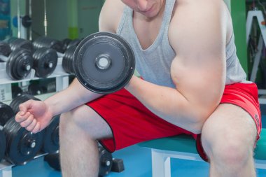adam dumbbells ile çalışmaları yapan.