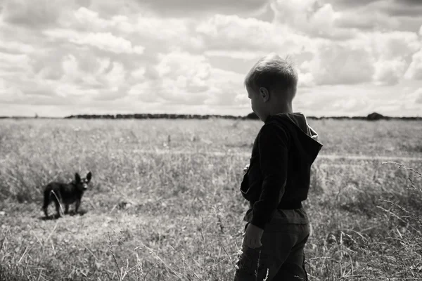 Junge und schwarzer Hund in der Natur — Stockfoto
