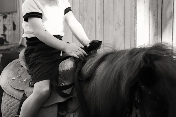 Pequeño niño montando pony — Foto de Stock