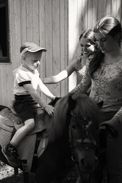 Pequeño niño montando pony — Foto de Stock