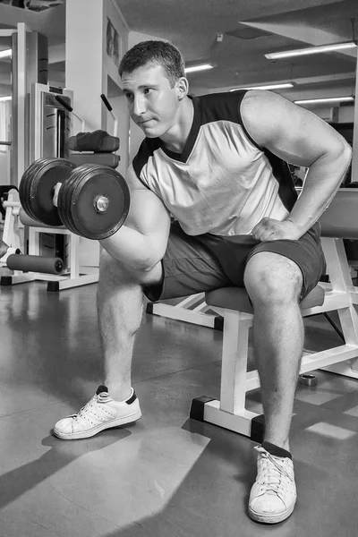 Homem faz exercícios com halteres . — Fotografia de Stock