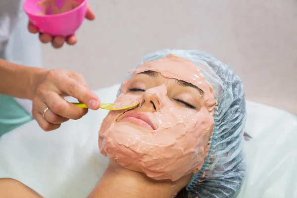 Woman receiving facial mask — Stock Photo, Image