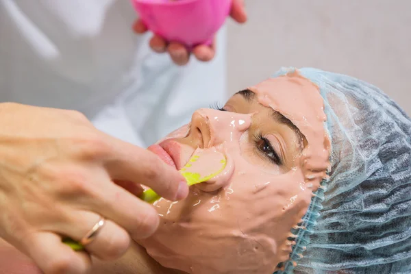 Woman receiving facial mask — Stock Photo, Image