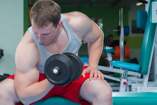 Man makes exercises with dumbbells. — Stock Photo, Image