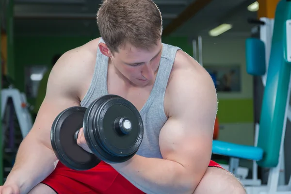 Adam dumbbells ile çalışmaları yapan. — Stok fotoğraf