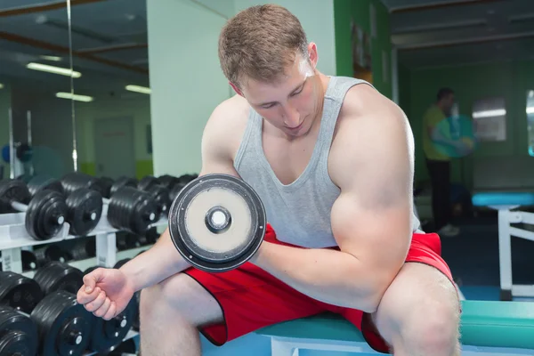 Adam dumbbells ile çalışmaları yapan. — Stok fotoğraf