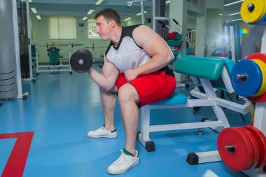 adam dumbbells ile çalışmaları yapan