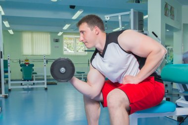 adam dumbbells ile çalışmaları yapan