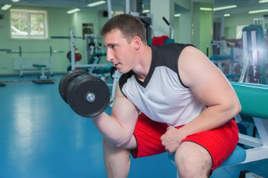 adam dumbbells ile çalışmaları yapan