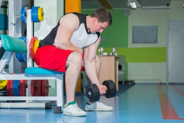 adam dumbbells ile çalışmaları yapan