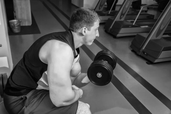 Man makes exercises with dumbbells — Stock Photo, Image