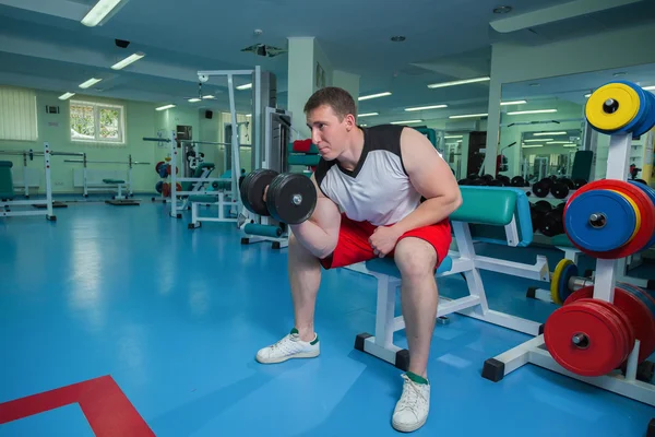 Adam dumbbells ile çalışmaları yapan — Stok fotoğraf