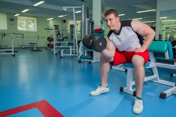 Man makes exercises with dumbbells — Stock Photo, Image