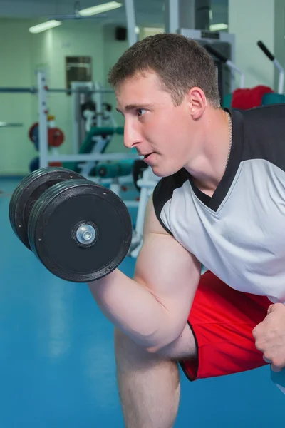 Man makes exercises with dumbbells — Stock Photo, Image