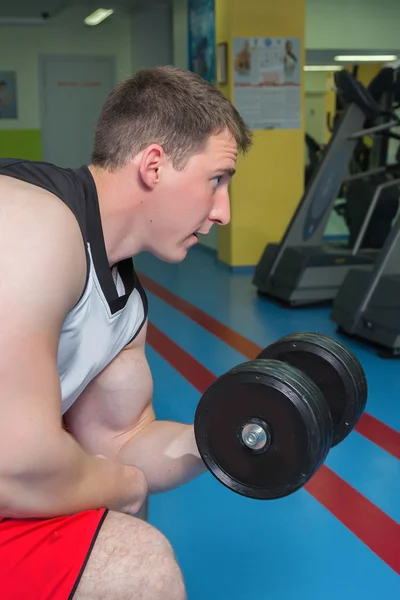 Man makes exercises with dumbbells — Stock Photo, Image