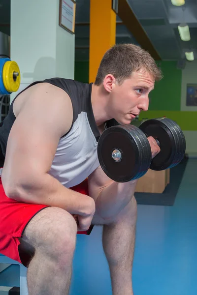 Man makes exercises with dumbbells — Stock Photo, Image