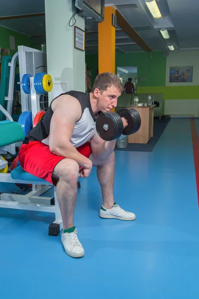 Man makes exercises with dumbbells — Stock Photo, Image