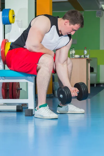 Man makes exercises with dumbbells — Stock Photo, Image