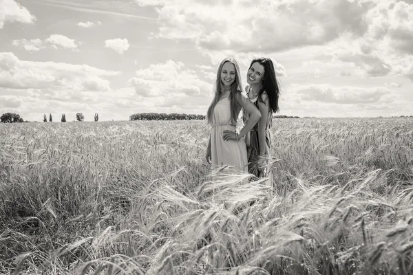 Mädchen stehen in einem Weizenfeld — Stockfoto
