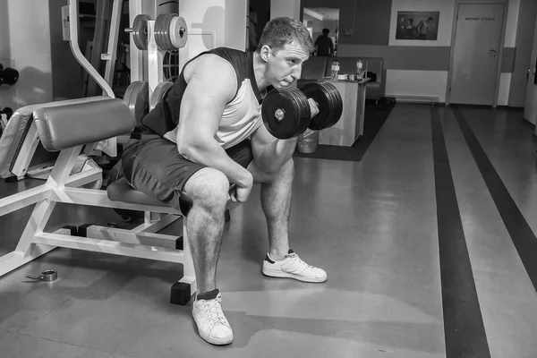 Man makes exercises with dumbbells — Stock Photo, Image