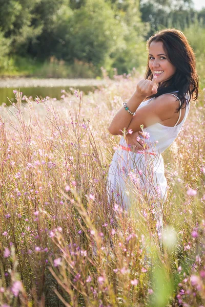 Brunette woman in summer field — Stock Photo, Image