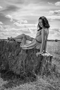 taş üzerine oturan esmer kadın